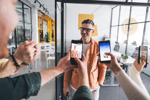 Preview: Cheerful man posing for picture of coworkers in office