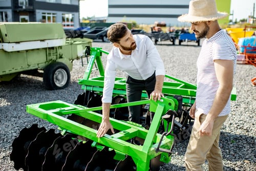 Preview: Agronomist with salesman at the shop with agricultural machinery