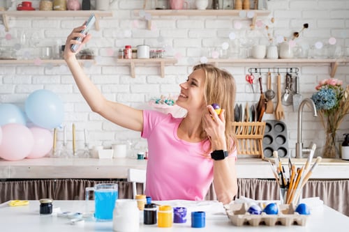 Preview: Smiling Woman Taking Selfie While Painting Eggs
