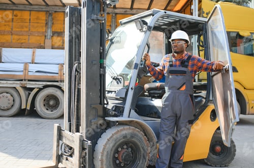 Preview: Portrait of a happy African American male worker driving forklift at workplace