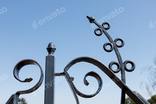 Preview: Detail with a wrought iron pattern on the balcony terrace against a clear sky background
