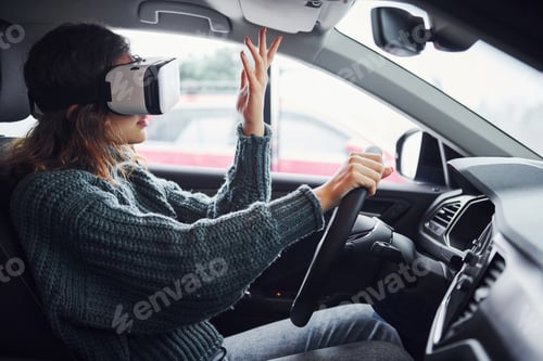 Preview: Side view of woman in virtual reality glasses that sitting inside of modern car