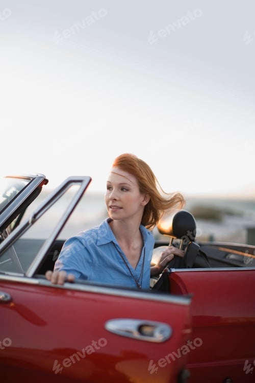 Preview: Red haired girl sitting in red car