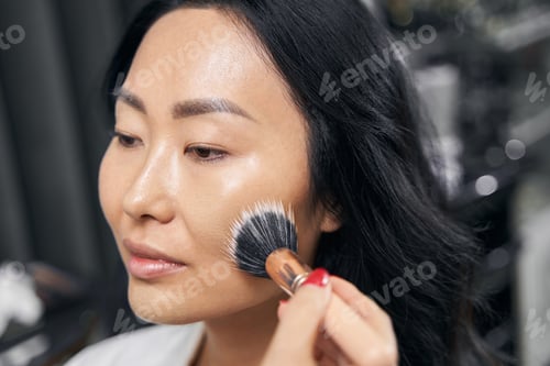 Preview: Charming elegant female receiving paint cosmetics in room indoors