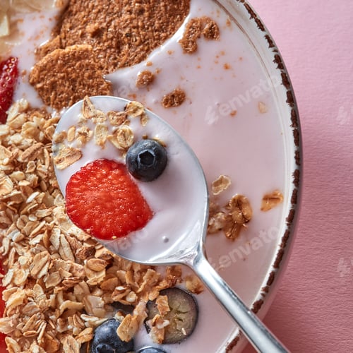 Preview: Organic granola with pieces of juicy strawberries, oat flakes, yogurt, almons in a ceramic bowls on
