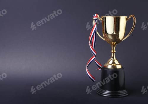Preview: Golden trophy cup with ribbon on grey background. Space for text