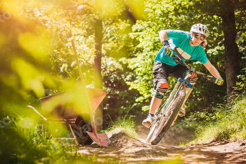 Preview: Young female mountain biker riding forest track