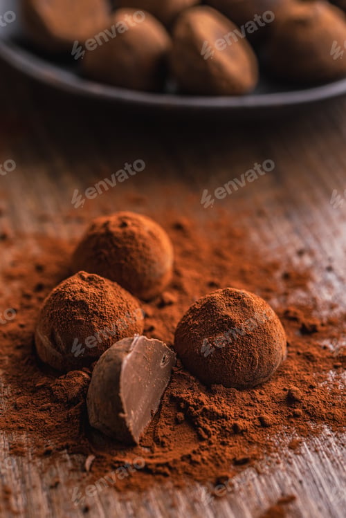 Preview: Chocolate truffles covered with cocoa powder on wooden table.