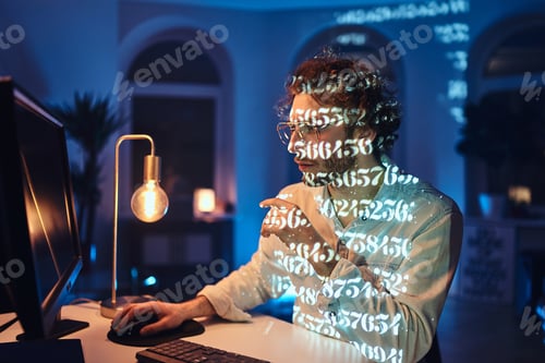 Preview: Concentrated on work caucasian guy using desk computer in dark room