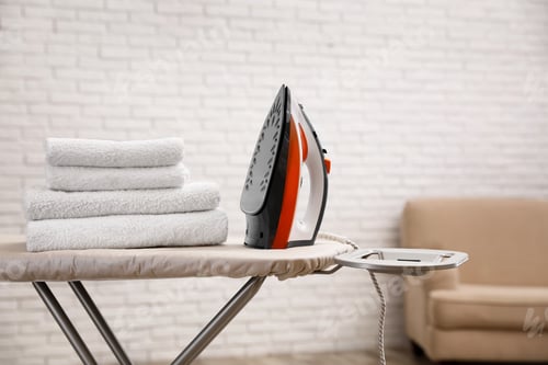 Vista previa: New modern iron and clean towels on board indoors, space for text. Laundry day