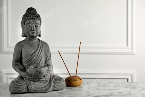 Preview: Buddha statue and incense sticks on white marble table. Space for text