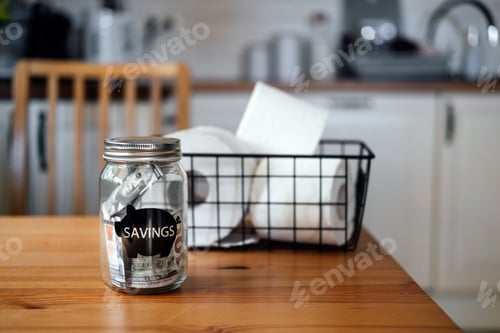 Preview: Frugal living, save money, live cheap concept with toilet paper basket and saving money jar on