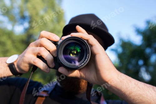 Preview: Close-up of man holding camera outdoors