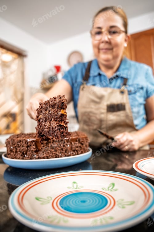 Preview: Pastry chef serving slice of chocolate cake in kitchen