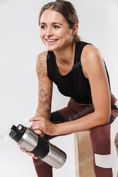 Preview: Pleased sports woman isolated over white wall background have a rest drinking water.
