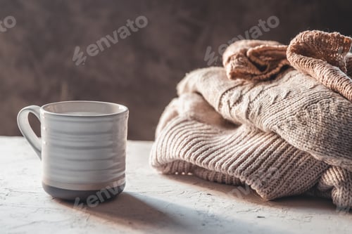 Preview: Cups of coffee with knitted warm pastel color sweaters