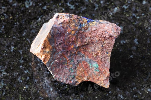 Preview: sample of raw zarinite rock on black granite