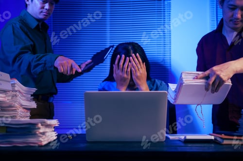 Preview: Two men bring a large workload to a woman at her desk in the office. She feels stressed pressured