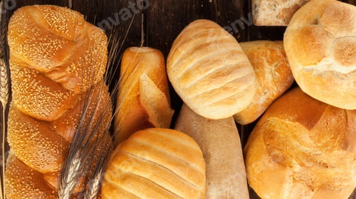 Preview: Variety of freshly baked bread loaves on rustic wooden table