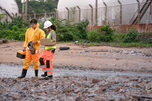 Preview: environmental researchers walk back from shoreline testing. They carry safety