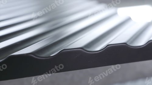 Preview: Close up side of black wavy roof tiles on blurred background. Action. Black wavy roofing material
