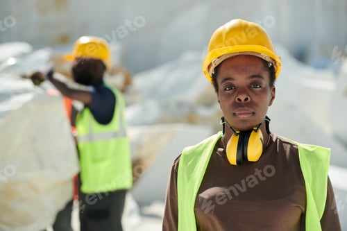 Preview: Young serious African American female worker of marble quarry looking at camera