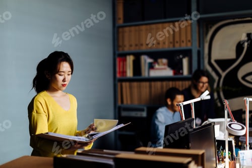 Preview: Young woman looking at files in office