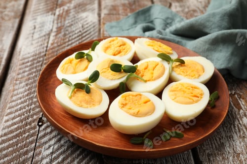 Preview: Hard boiled eggs with microgreens on wooden table, closeup