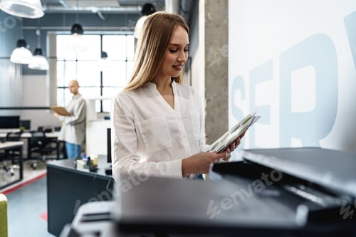 Preview: Young employee using modern printer in office