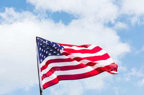 Preview: low angle view of flag with stars and stripes against blue sky