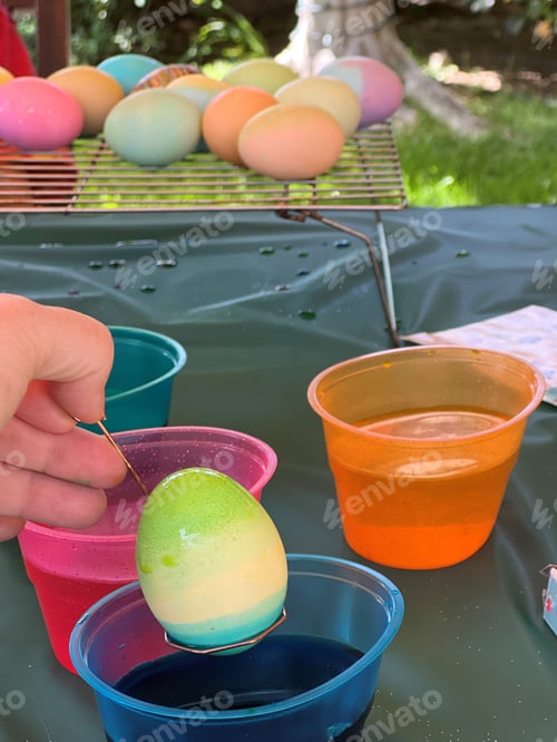 Preview: coloring an easter egg green and blue and various pastel easter eggs in the background on spring day