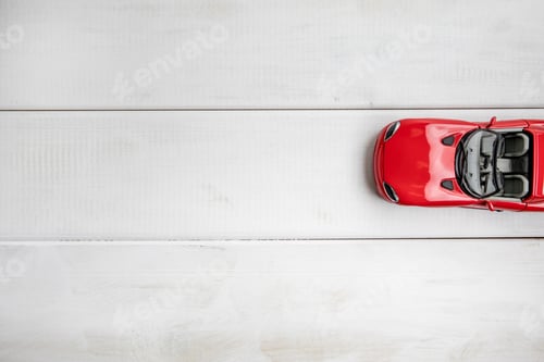 Preview: Small toy car on a white wooden background.