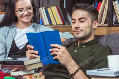 Preview: smiling young couple of students reading books together