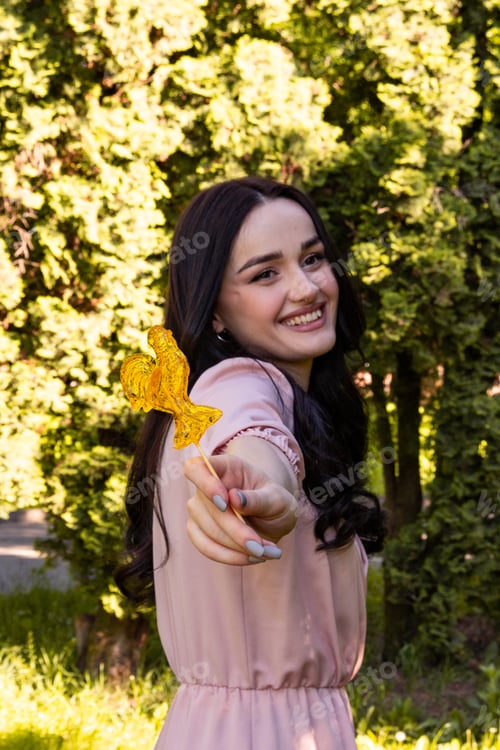 Preview: A young beautiful girl in a pale pink dress on the background of a green park