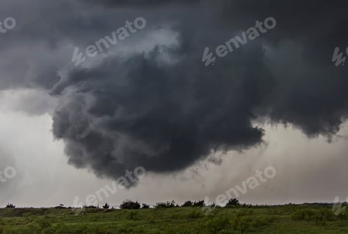 Preview: Ominous storm clouds gather above a landscape.