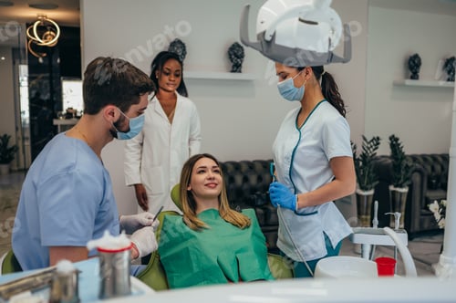 Preview: Woman patient in dental clinic being examined by a male dentist
