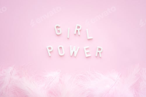 Preview: Inscription: girl power from white plaster letters on a pink background with feathers.
