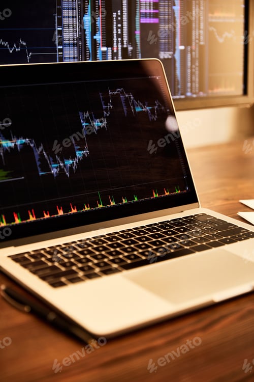 Preview: laptop and computer with charts and graphs on table