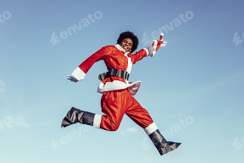 Preview: black ethnicity santa claus jumping with excitement and smiling to the camera