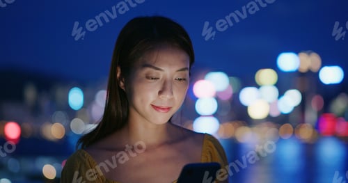 Preview: Woman look at smart phone at night