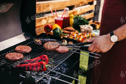 Preview: Chef cooking patties and vegetables grilled for outdoors barbecue