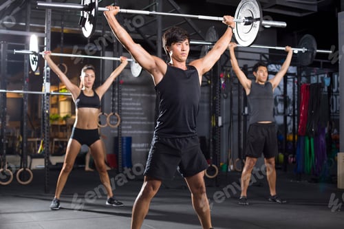 Preview: Young athletes lifting barbells at gym