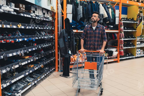 Preview: a customer with a cart in a hardware store chooses a padlock for a gate.