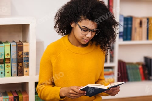 Preview: Image of serious african american woman reading book while sitting