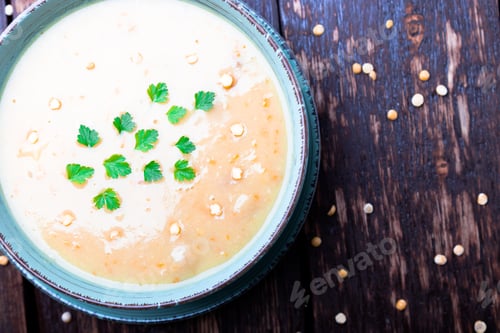 Preview: Pea soup in green bowl on brown wooden background. Top view. Dry yellow pea. Vegan food.