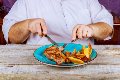 Preview: Man nutritious lunch restaurant pork steaks with roasted potato