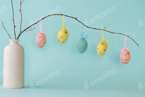 Preview: Easter composition with eggs hanging on dry branch placed in vase