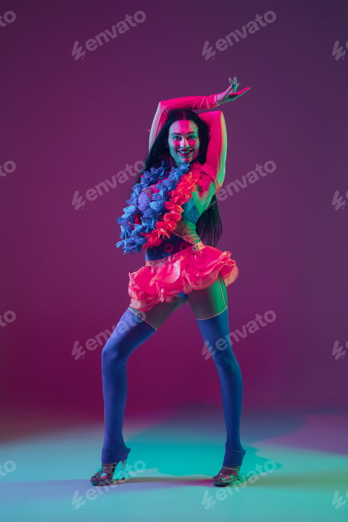 Preview: Attractive hawaiian brunette model on purple studio background in neon light