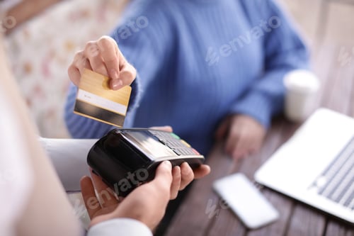 Preview: Woman with credit card using payment terminal at restaurant, closeup