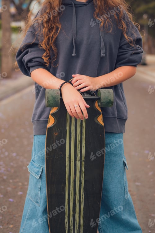 Preview: Close-up of a young woman with a skate on a road of a street